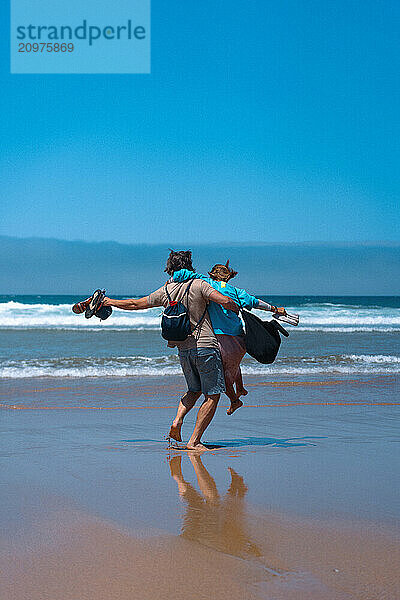 Happy friends hugging on the beach.