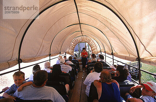 Covered wagon full of tourists.