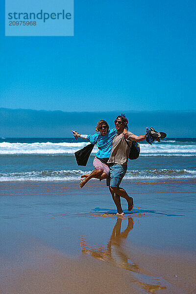 Happy friends hugging on the beach.