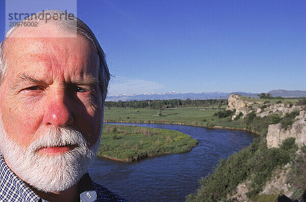 Man standing beside a river.