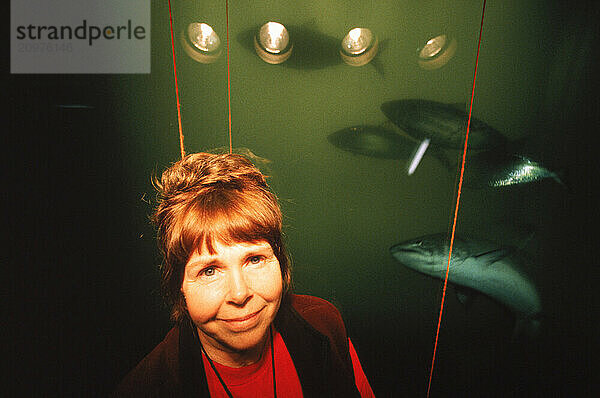 A woman in front of a fish window.