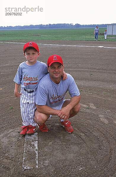 Father and sun at a baseball game.