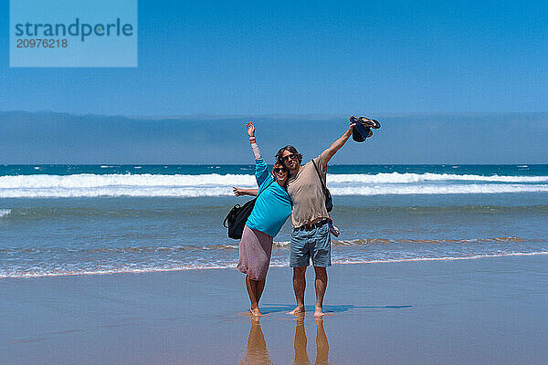 Happy friends hugging on the beach.