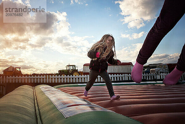 Happy little girl on bounce pad at pumpkin farm