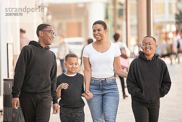 African American Woman walking downtown with three sons