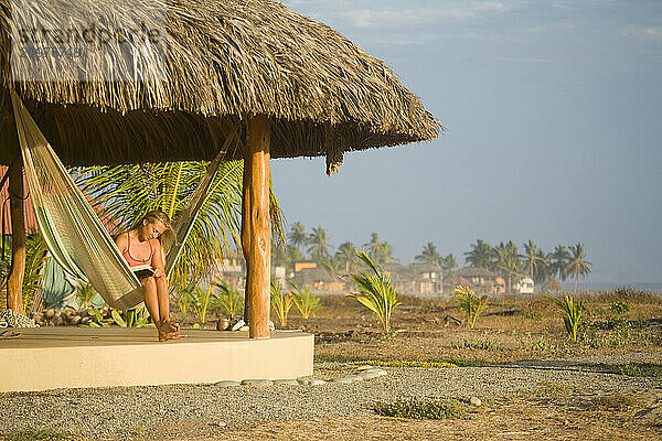 Young woman relaxing in hammock in Mexico.