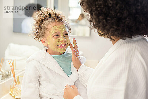 Little sister is looking at big sister and smiling