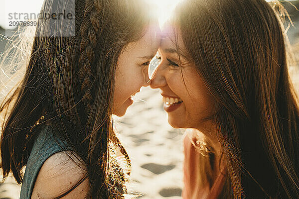 Close up of Mother daughter looking into eyes forehead together