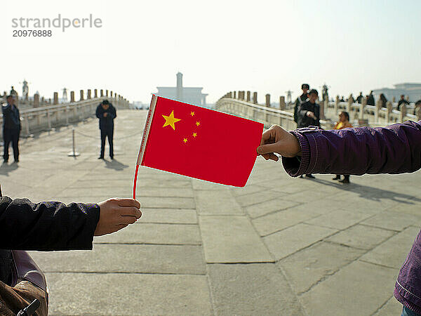 Hands holding Chinese flag