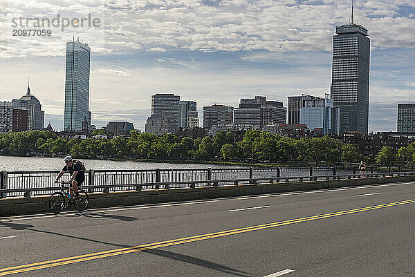 Cyclist riding along city bridge  Boston  Massachusetts  USA