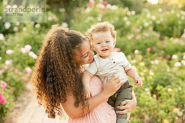 Sister holding brother and smiling in garden