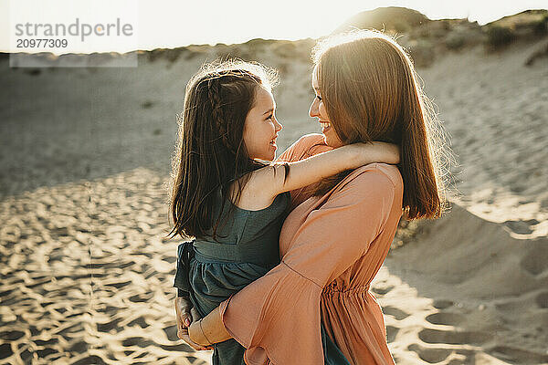 Sweet moment Happy Mother daughter at beach summer sunset smiling