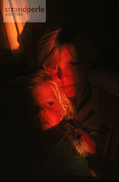 Portrait of mother and daughter in a dark room in Maine.