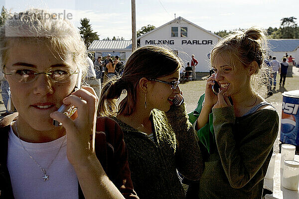 Girls talk on their cell phones  Fryeburg Fair  Maine.