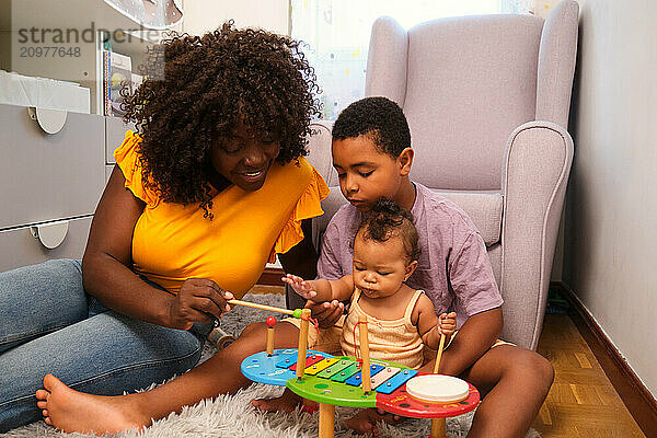 Happy family playing music together with a xylophone