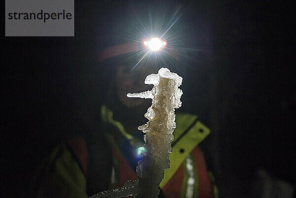 Scientist showing ice on equipment during ice storm research