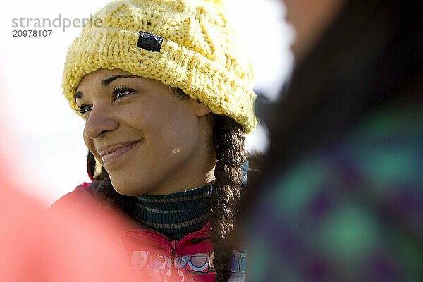 Girls in ski clothes socialize outdoors on a sunny day on the mountain.