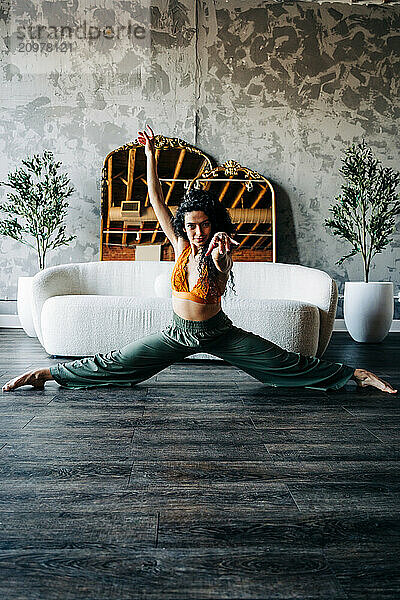 Woman confidently posing with greenery and mirrors.