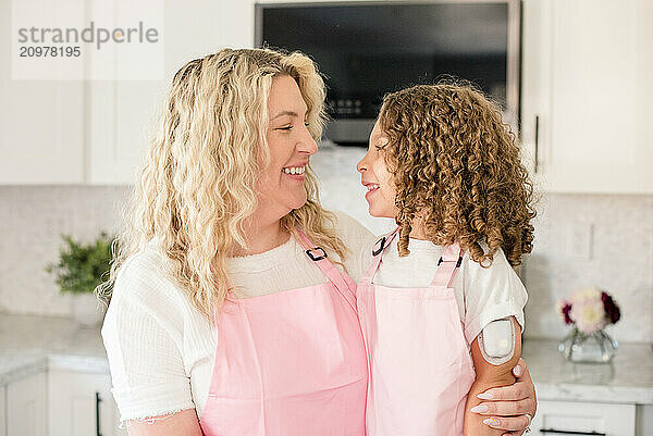 Mother and daughter smiling at each other in the kitchen