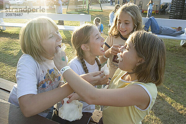 Girls enjoying maple sugar cotton candy at the Fryeburg Fair in Maine.