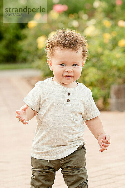 Baby walking in the garden of roses