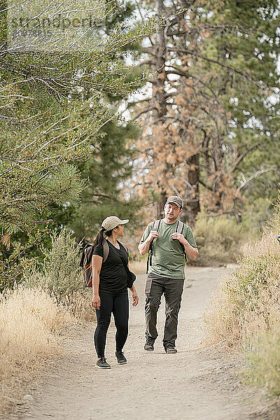 Couple walking down trail together in woods