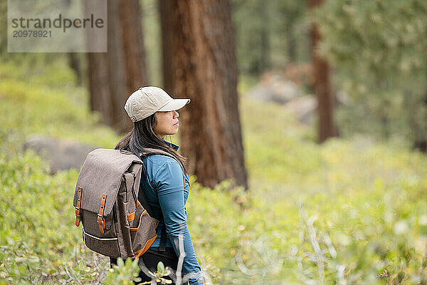 Woman hiker looking around in the forest