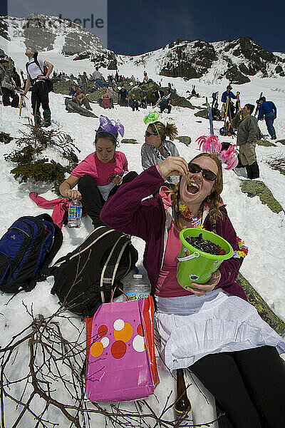 Skiers eat snacks while resting on Tuckerman Ravine on Mount Washington in the White Mountains of New Hampshire.