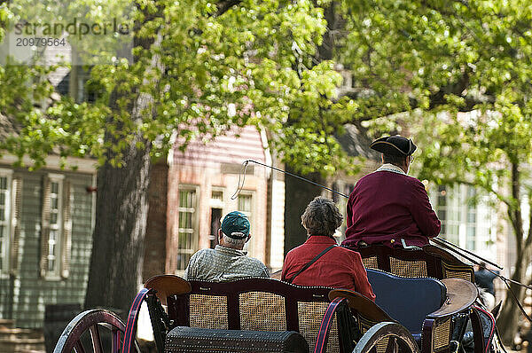 Tourists taking a ride on a period horse and buggy in Colonial WIlliamsburg  Virginia.