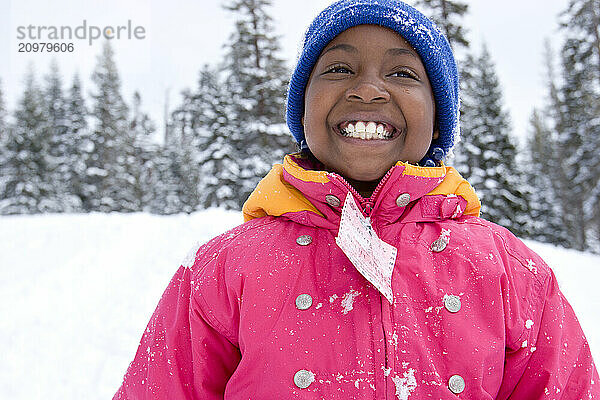 Young girl in a pink jacket playing in snow at Kirkwood ski resort near Lake Tahoe  California..