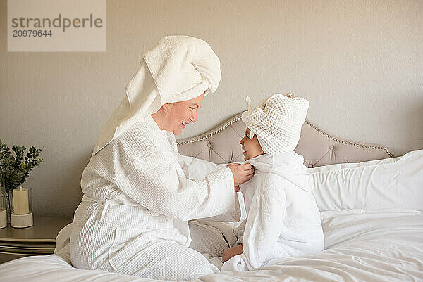 Mother and daughter in white robes with towels