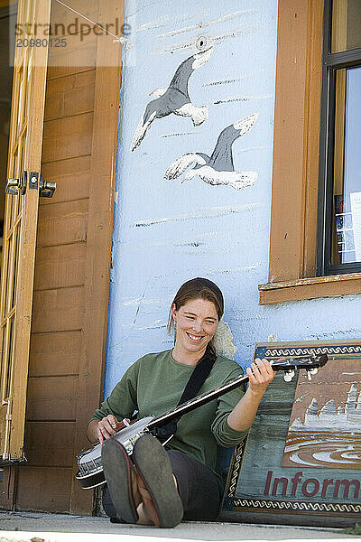 Young woman playing banjo in Lee Vining  CA