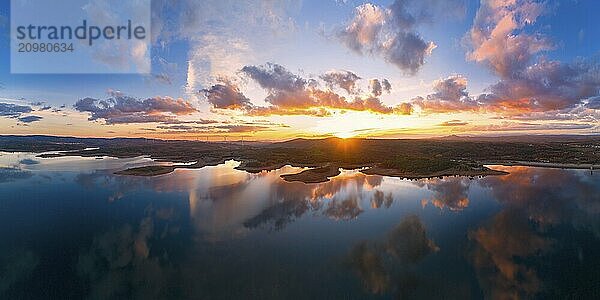 Drone aerial panorama of a lake reservoir of a dam with perfect reflection on the water of the sunset in Sabugal  Portugal  Europe