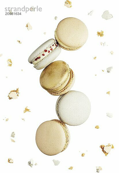 Isolated on white background white  yellow  gold macaron cookies flying  falling in motion or levitating. Colorful  sweet small French macaroon cakes. Five full cookies isolate. Broken cuts around