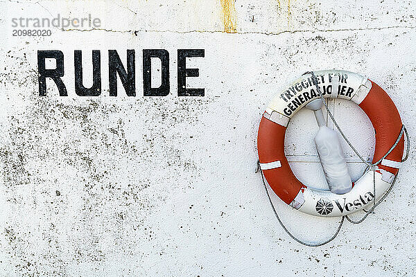 Lettering and lifebuoy on the harbour wall of Runde Island  Møre og Romsdal  Norway  Europe