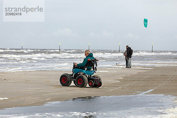 Man with handicap on the beach with a beach wheelchair  Sankt-Peter-Ording  Schleswig-Holstein