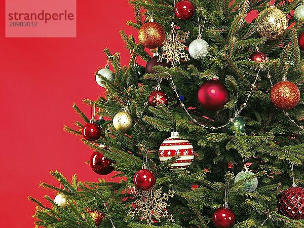 Closeup of Christmas tree colorful decoration on bright red background