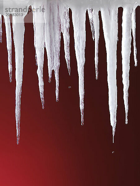 Melting icicles isolated on hot red background