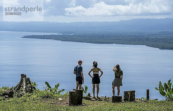 Three tourists look out over the South Pacific and rainforest  Osa Peninsula  Punterenas Province  Costa Rica  Central America