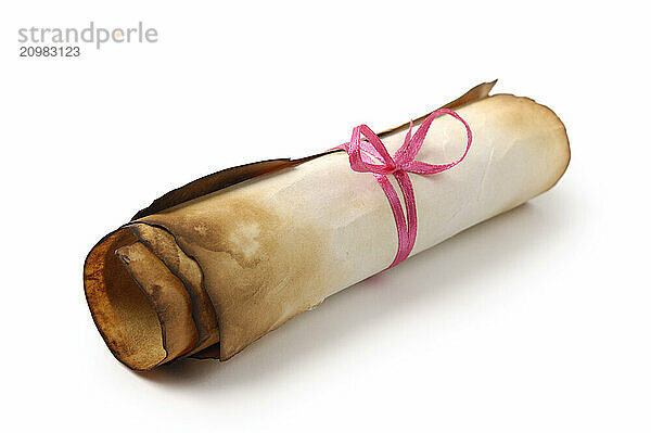 Roll of yellowish burnt vintage parchment tied with a red ribbon Isolated over white background