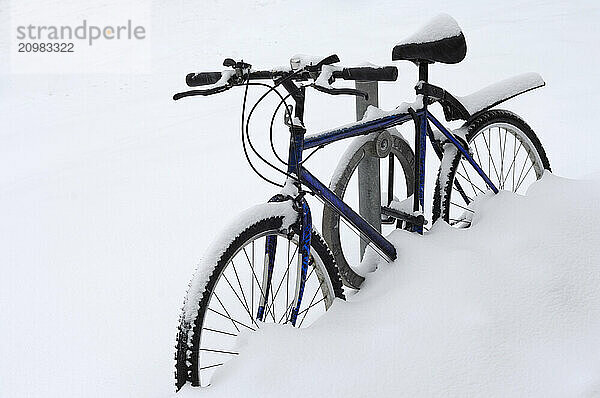 Bicycle on the side of the road covered with snow in winter