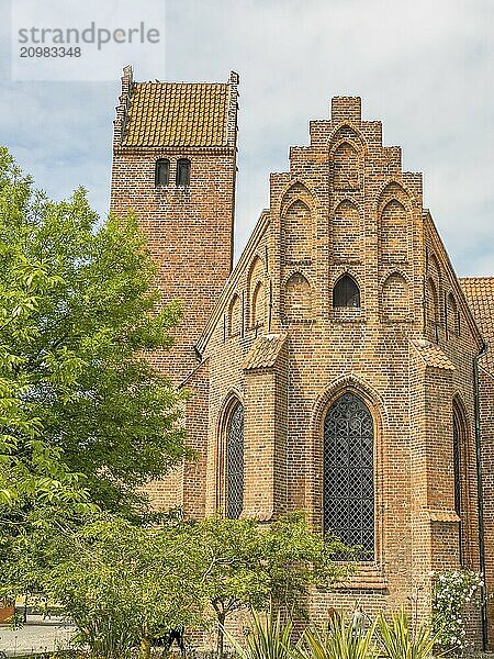 Historic brick church with a high tower  surrounded by green trees  ystad  sweden  baltic sea  scandinavia