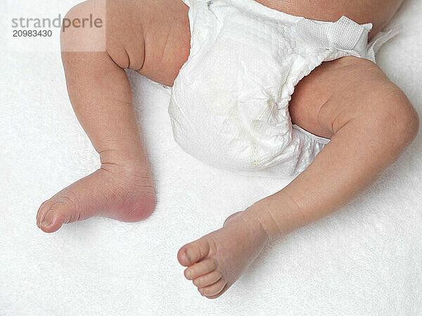 Closeup of legs of a newborn baby wearing a diaper