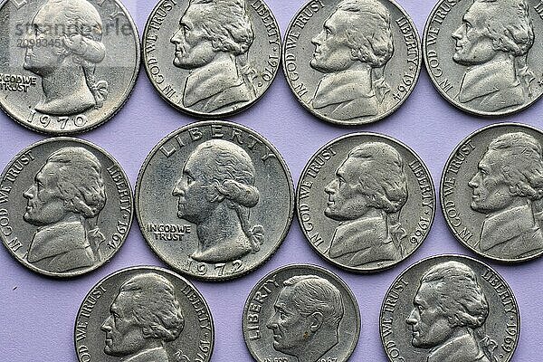 Assortment of old nickel  dime and quarter coins on purple background