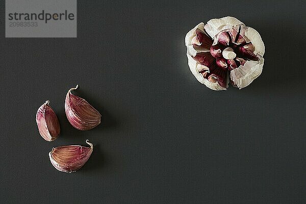 Garlic cloves over a dark background seen from above