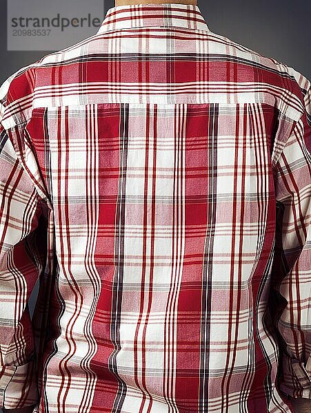 Closeup of a back of a man wearing fancy red tartan shirt on grey background. Rear view