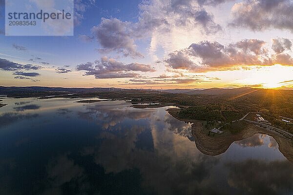 Drone aerial view of a lake reservoir of a dam with perfect reflection on the water of the sunset in Sabugal  Portugal  Europe