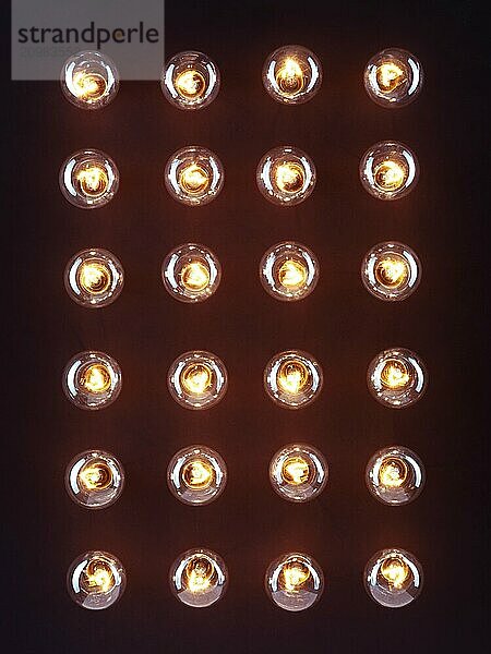 A group of illuminated incandescent light bulbs shining isolated on black background