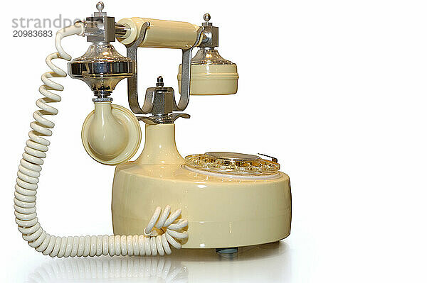 Classic series Paramount collection antique style rotary ivory plastic with chrome details telephone. Isolated retro object silhouette on white background with clipping path and copy space. Communication history concept