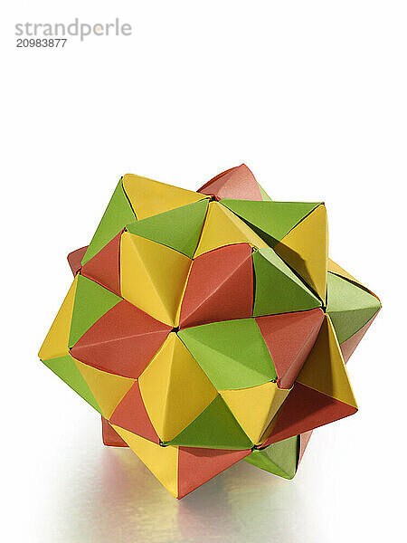 Stock photo of Colorful bright Origami abstract figure polyhedron made from folded paper Hand made Christmas holiday decoration Isolated silhouette on white background with a clipping path